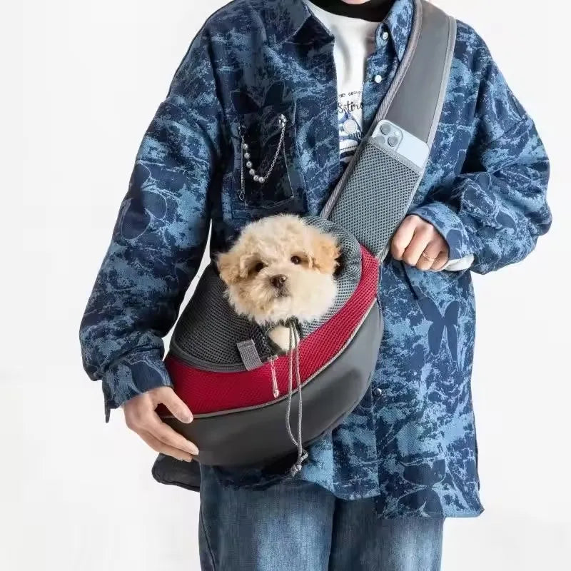 Red mesh pet sling worn crossbody with a small dog