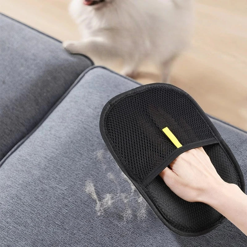 Black pet hair mitt lifting fur from a gray sofa