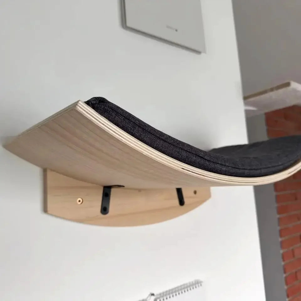 Curved carpeted cat perch mounted on a wall