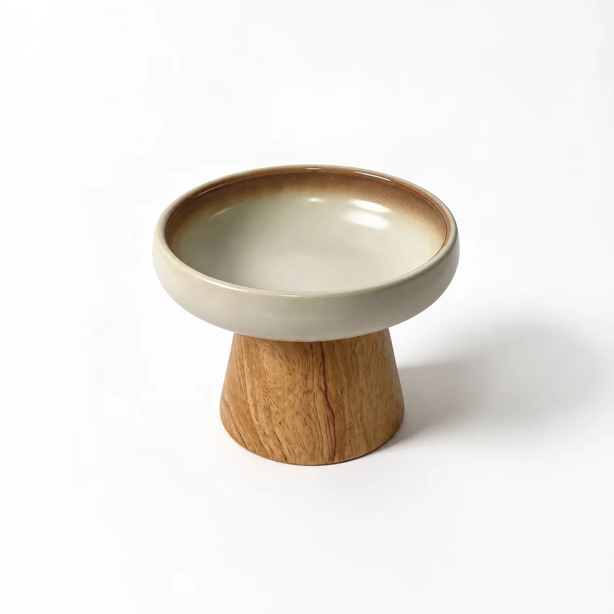Cream ceramic cat bowl on a natural wood stand